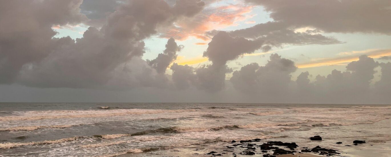 ocean waves crashing on shore during sunset